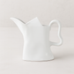 Handmade creamy white ceramic pitcher with organic shape and curved handle, 9"H.