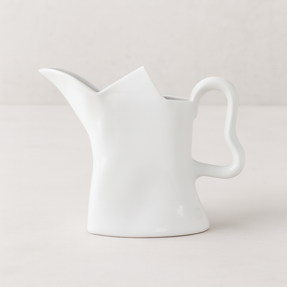 Handmade creamy white ceramic pitcher with organic shape and curved handle, 9"H.