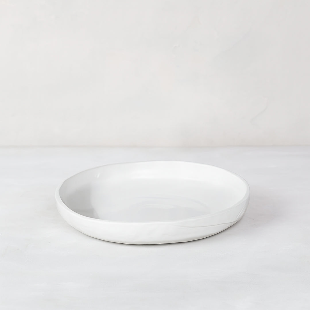 White handmade ceramic platter 5316-S by Montes Doggett, round with organic shape and raised edge.