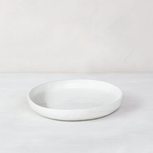 White handmade ceramic platter 5316-S by Montes Doggett, round with organic shape and raised edge.
