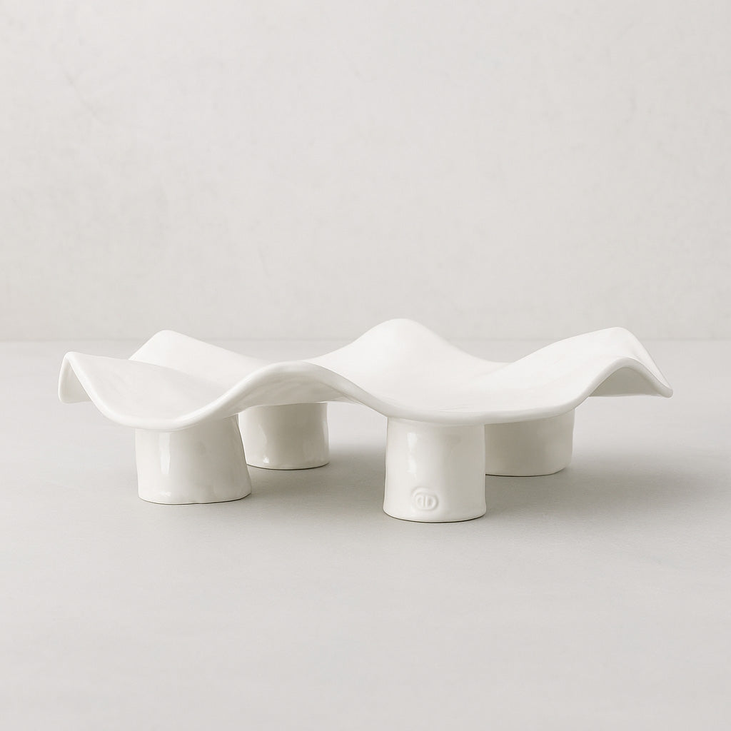 Handmade creamy white ceramic platter 5450 by Montes Doggett, organic wavy shape on four legs.