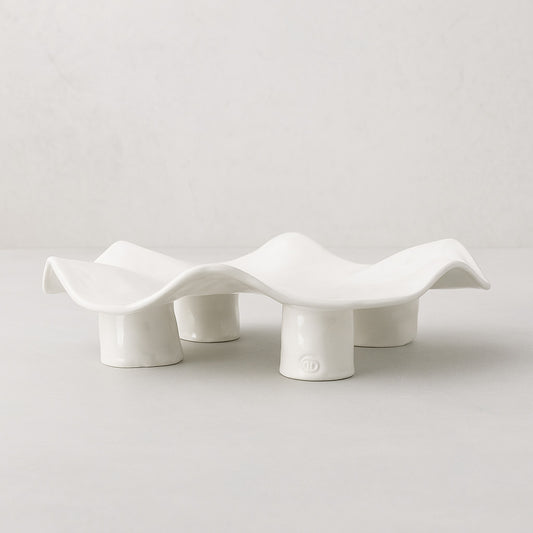 Handmade creamy white ceramic platter 5450 by Montes Doggett, organic wavy shape on four legs.