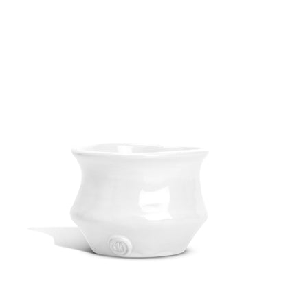 Handmade creamy white ceramic serve bowl with organic shape and Montes Doggett logo.