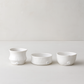 Set of 3 handmade Montes Doggett creamy white ceramic serve bowls, various organic shapes.