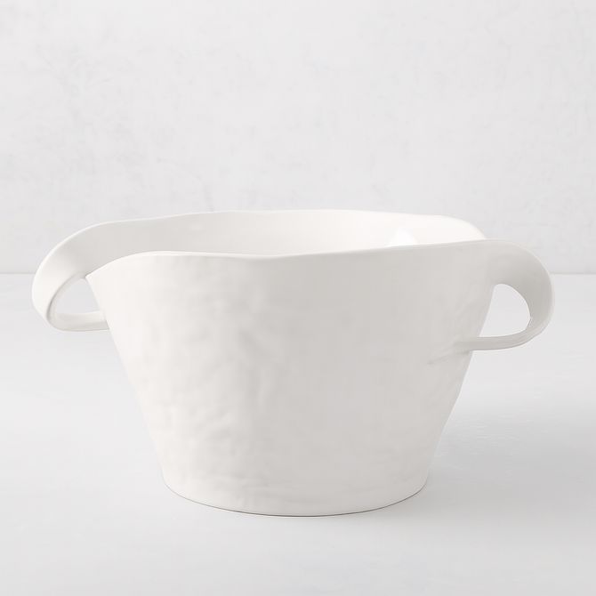 Handmade Montes Doggett ceramic serve bowl, creamy white glaze, sculptural wavy rim, and two small handles.