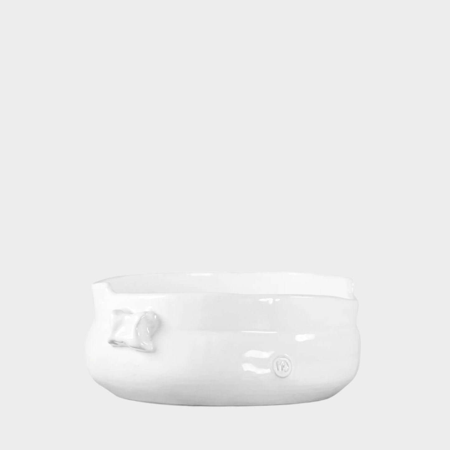 Handmade creamy white ceramic serve bowl with organic shape and subtle embossed details.