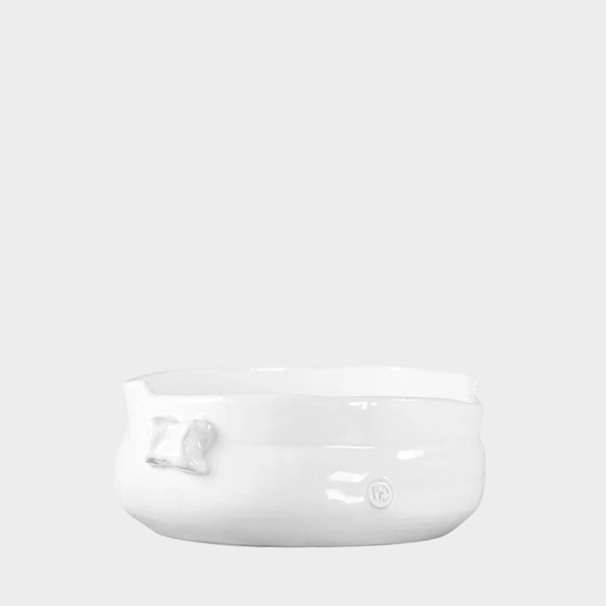 Handmade creamy white ceramic serve bowl with organic shape and subtle embossed details.