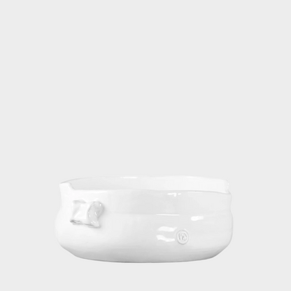 Handmade creamy white ceramic serve bowl with organic shape and subtle embossed details.