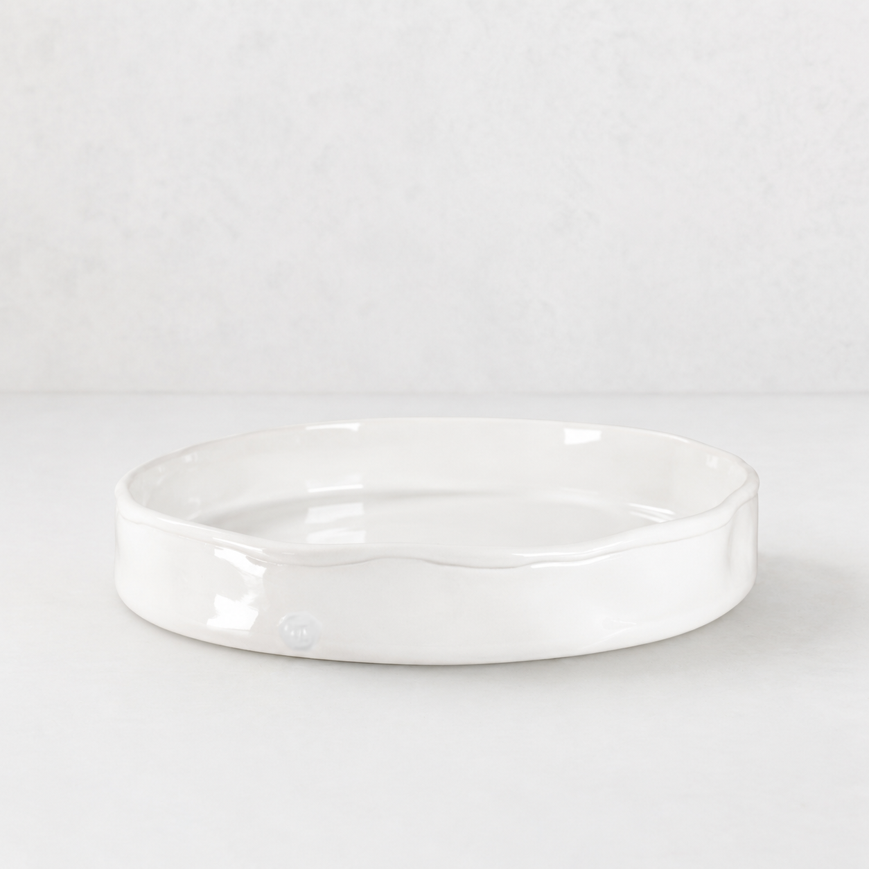 Handmade Montes Doggett ceramic tray, creamy white glaze, 11" round, wavy rim.