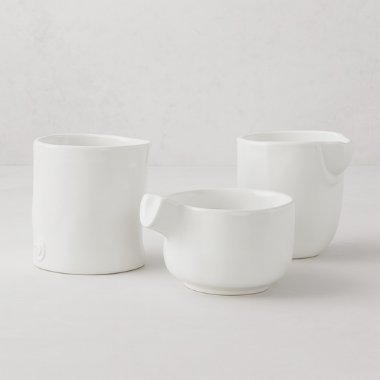 Set of 3 handmade Montes Doggett creamy white ceramic tumblers, various sizes, unique designs.
