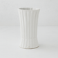 Handmade creamy white ceramic vase by Montes Doggett, 11.5"H, with vertical ridges and a flared base.