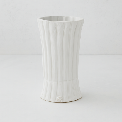Handmade creamy white ceramic vase by Montes Doggett, 11.5"H, with vertical ridges and a flared base.