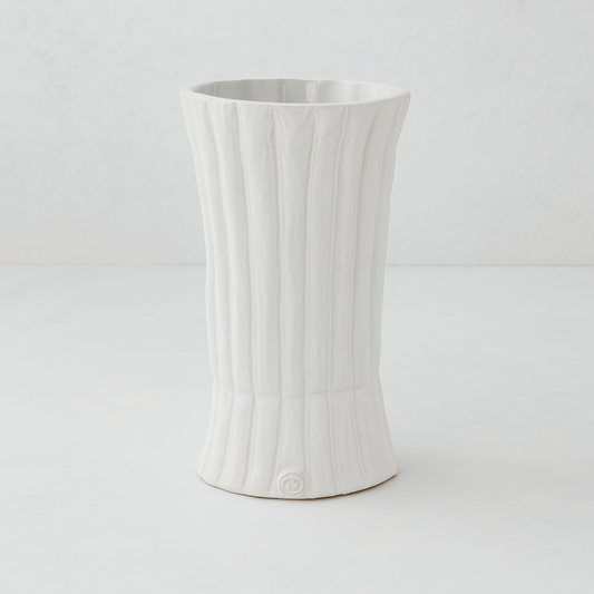 Handmade creamy white ceramic vase by Montes Doggett, 11.5"H, with vertical ridges and a flared base.