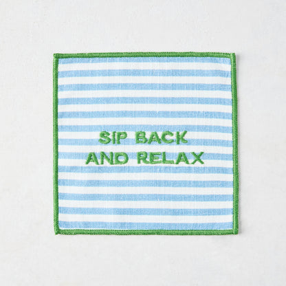 Blue and white striped cotton coaster with green embroidered "SIP BACK AND RELAX" text and green border.