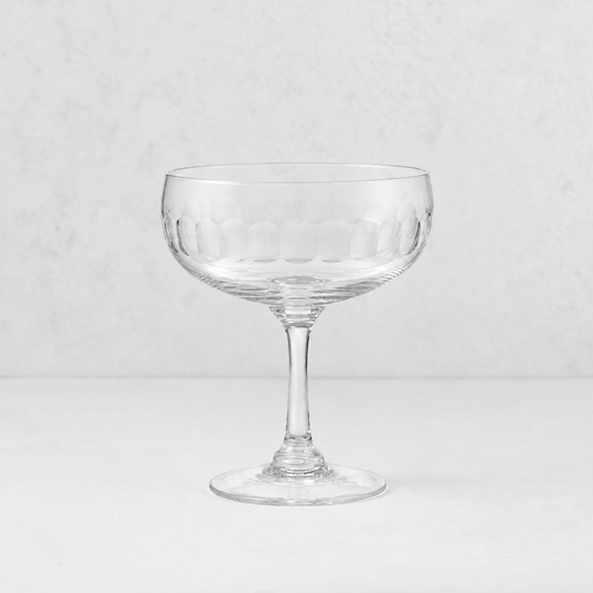 Harrington hand-blown lead-free crystal coupe glass with hand-cut oval pattern on a light background.