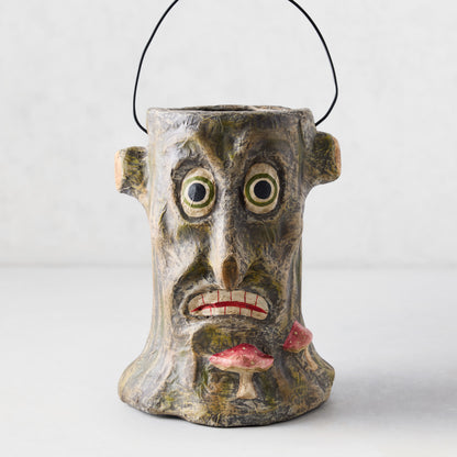 Handcrafted papier-mâché Halloween candy bucket shaped like a distressed tree stump with a spooky face and mushrooms.