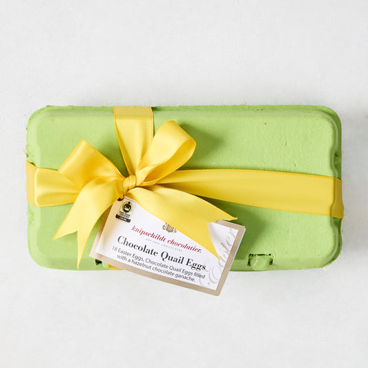 Green egg carton with yellow bow and "Chocolate Quail Eggs" tag.