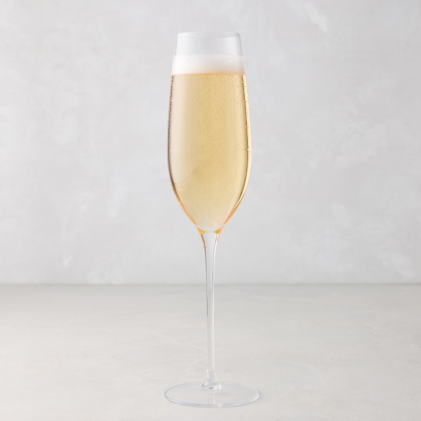 HG Heritage Champagne Glass, clear mouth-blown glass, filled with bubbly champagne.