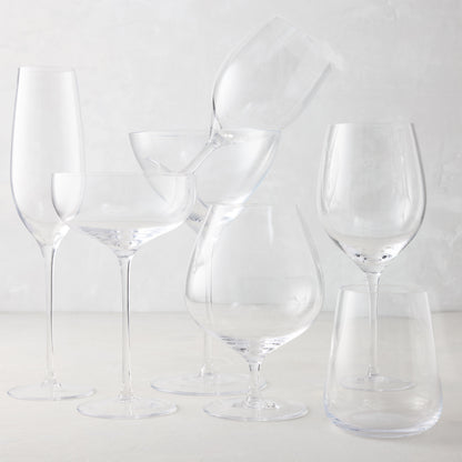 Clear mouth-blown HG Heritage Cognac Glass with a generous bowl, alongside other clear drinkware.