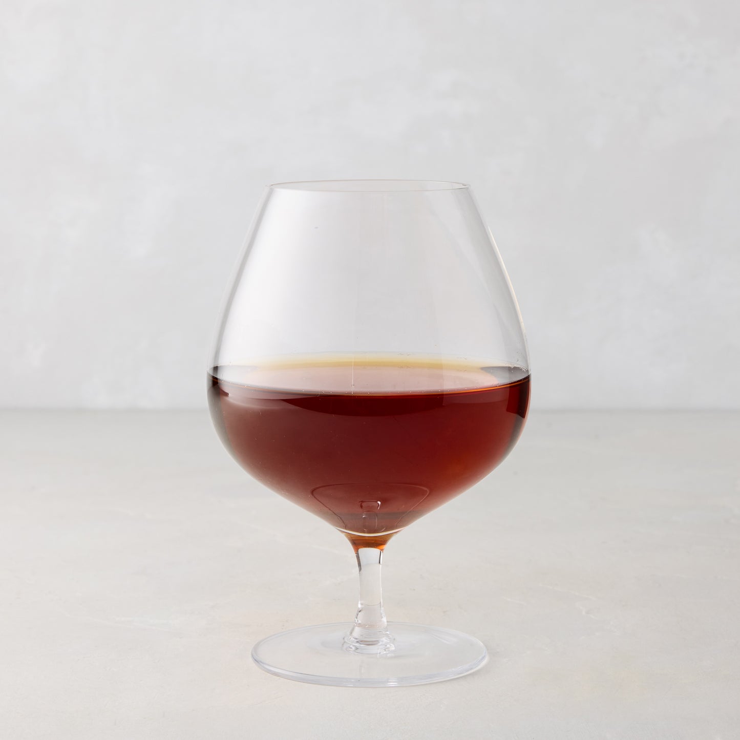 HG Heritage 20 oz mouth-blown clear glass cognac snifter with amber liquid.
