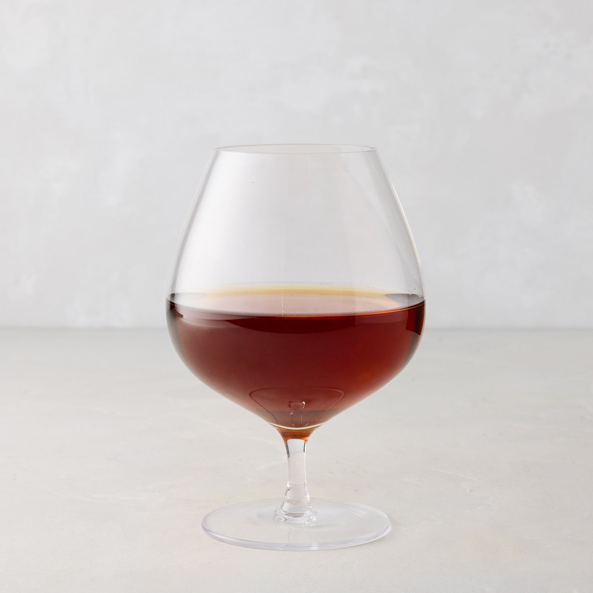 HG Heritage 20 oz mouth-blown clear glass cognac snifter with amber liquid.