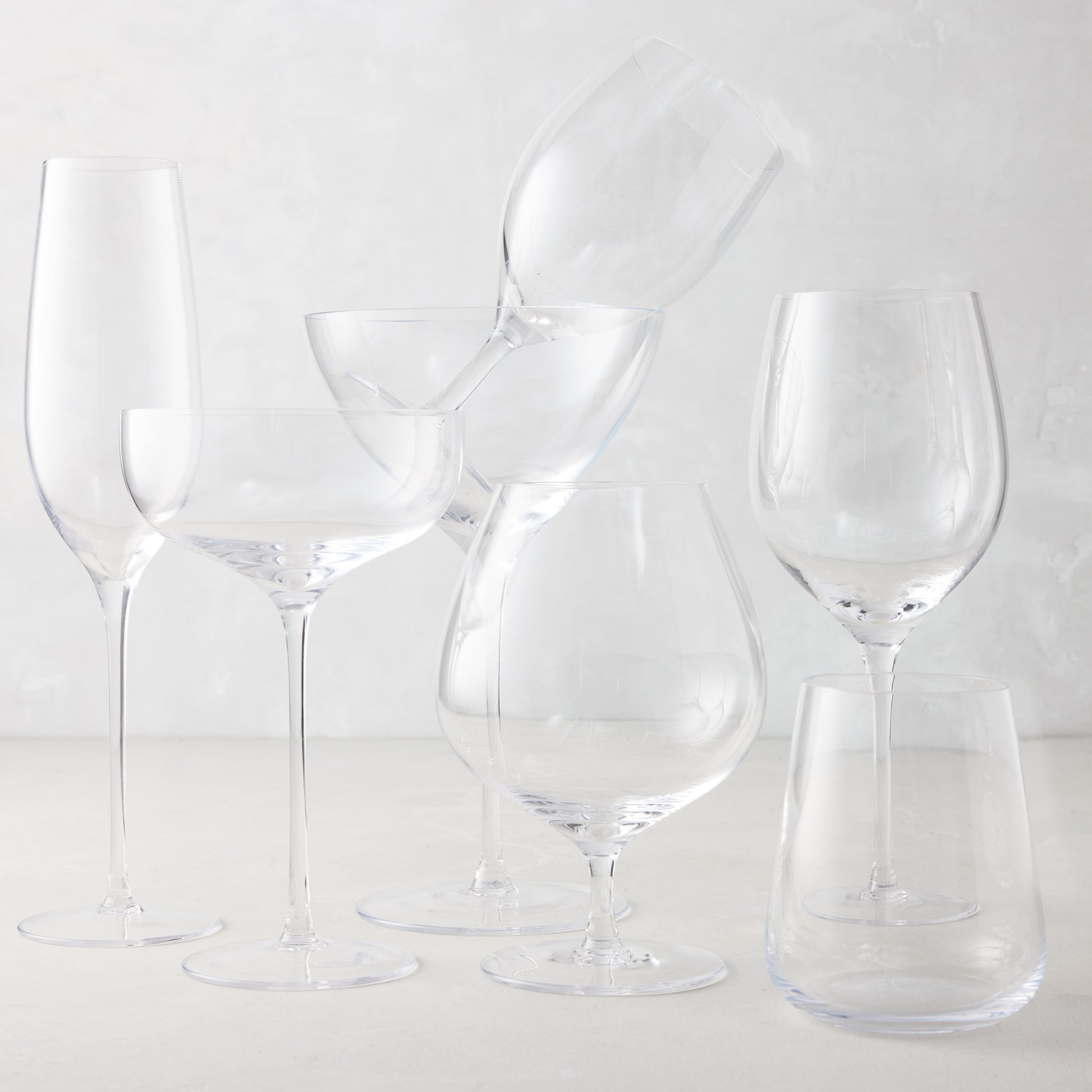 Clear, mouth-blown HG Heritage Water Glass and assorted drinkware collection on a light background.