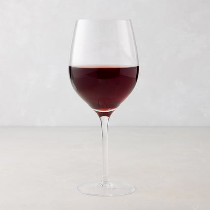 HG Heritage Wine Glass, clear mouth-blown glass, filled with red wine, on a light background.