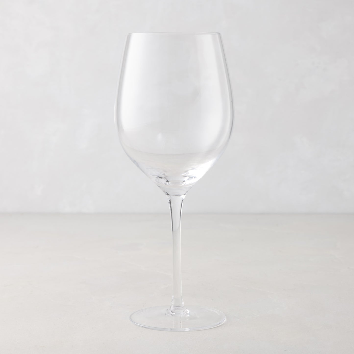 Clear, tall HG Heritage mouth-blown wine glass with a thin stem and wide bowl.