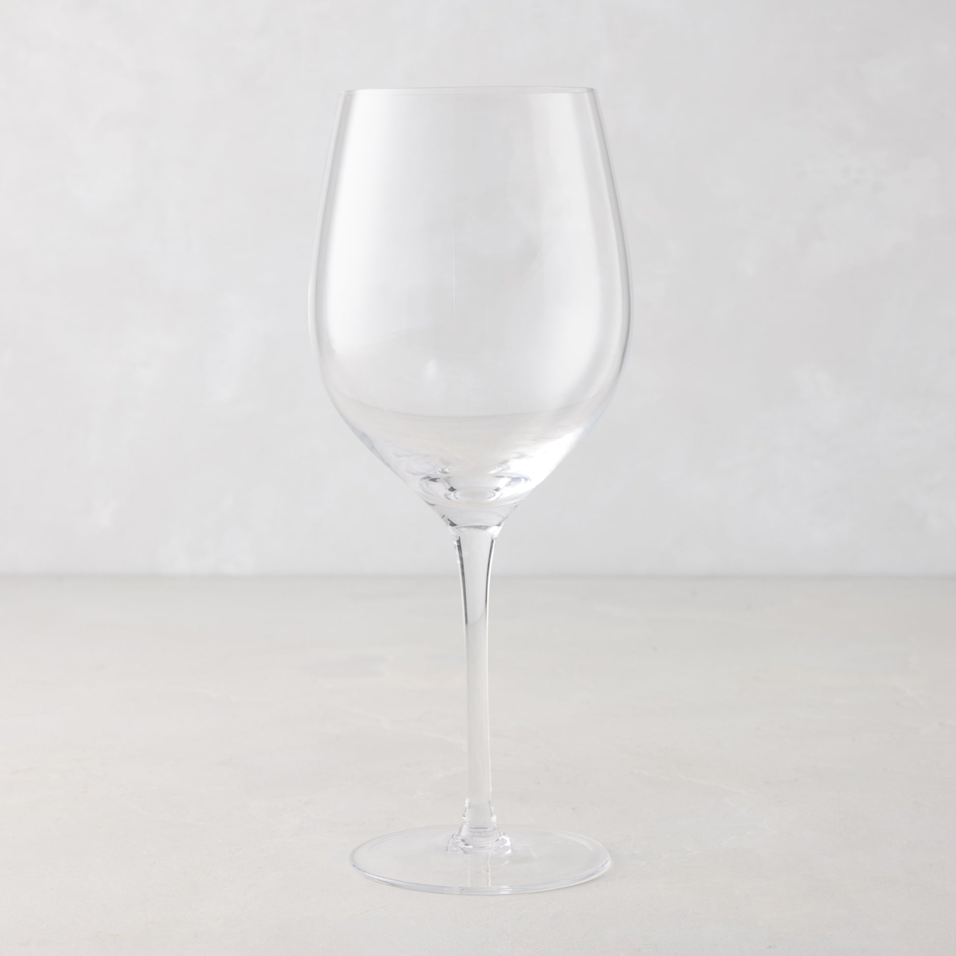 Clear, tall HG Heritage mouth-blown wine glass with a thin stem and wide bowl.