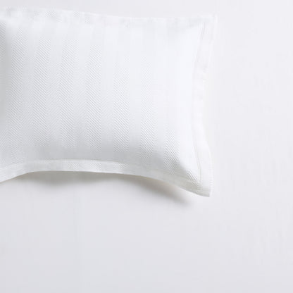 White cotton matelassé pillow sham with a subtle herringbone pattern and 2-inch hem.
