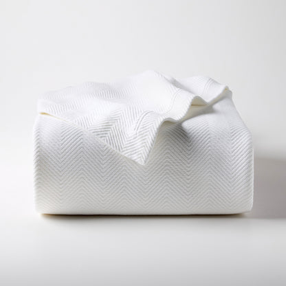 White Queen Matelassé Coverlet, 100% cotton with a subtle herringbone pattern, folded on a white surface.