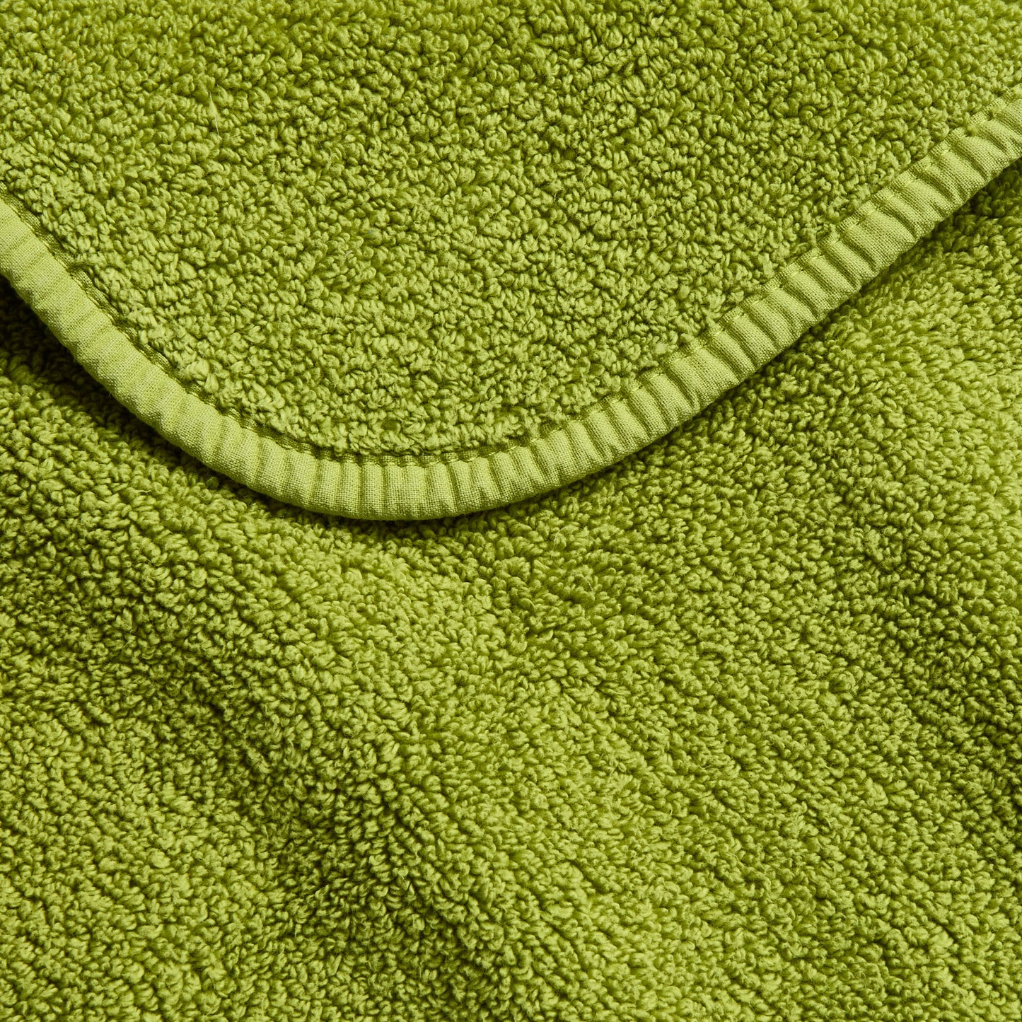 Aloe green zero twist cotton bath towel with textured terry fabric and matching bias piping trim.