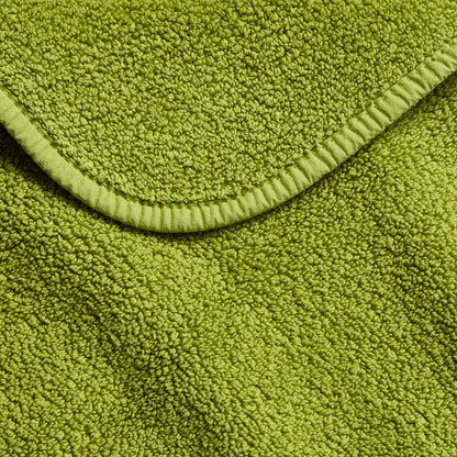 Aloe green zero twist cotton bath towel with textured terry fabric and matching bias piping trim.