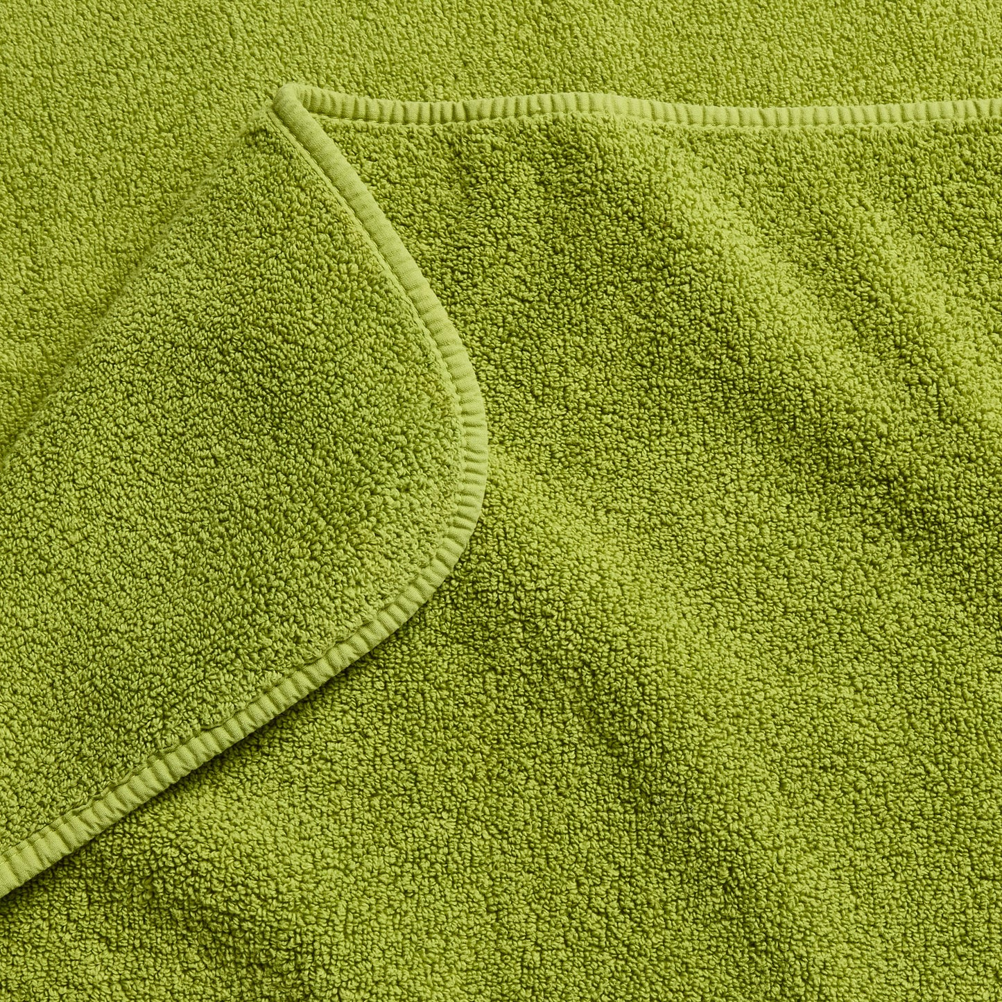 Aloe green zero-twist cotton bath towel with matching bias piping detail.