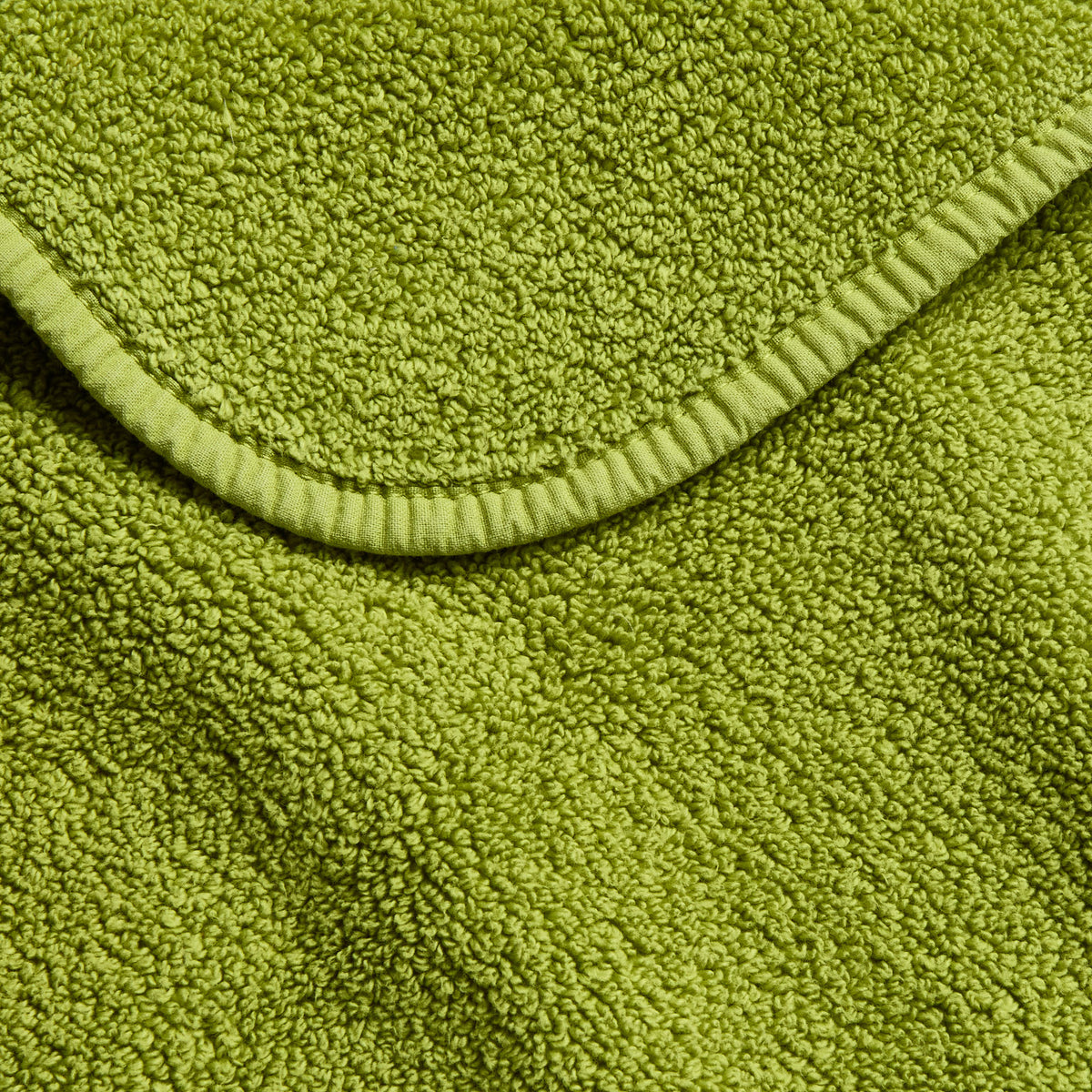 Aloe green zero twist cotton bath towel with textured terry fabric and matching bias piping trim.