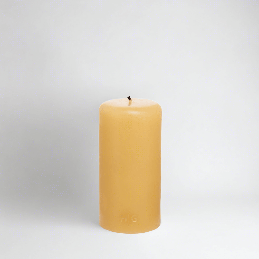HG Amber Unscented 3"x6" paraffin pillar candle with gold embossed HG logo and cotton wick.