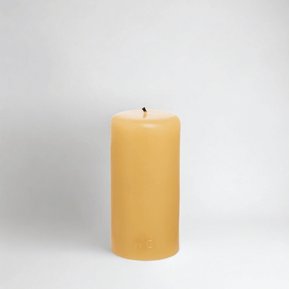 HG Amber Unscented 3"x6" paraffin pillar candle with gold embossed HG logo and cotton wick.