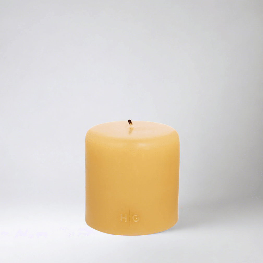 HG Amber Unscented Pillar Candle, 4"x4" paraffin with gold embossed HG logo and cotton wick.