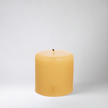 HG Amber Unscented Pillar Candle, 4"x4" paraffin with gold embossed HG logo and cotton wick.