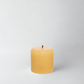 HG Amber Unscented Pillar Candle, 3"x3", with a gold embossed HG logo and black wick.