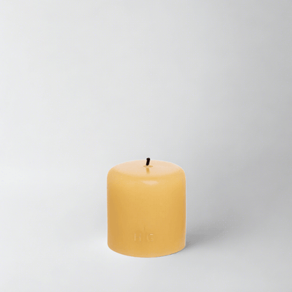 HG Amber Unscented Pillar Candle, 3"x3", with a gold embossed HG logo and black wick.