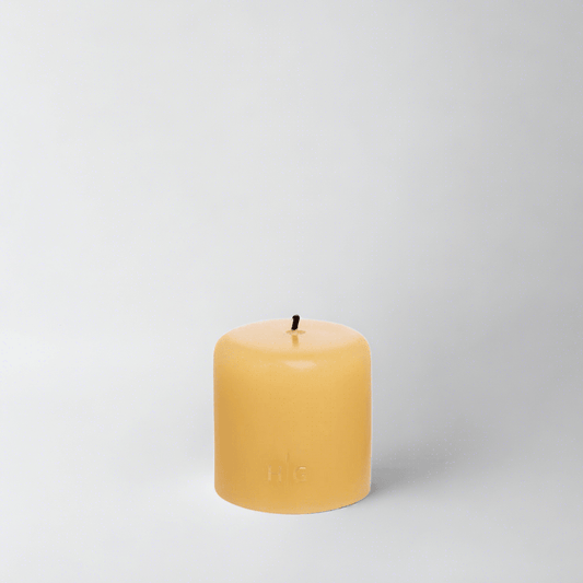 HG Amber Unscented Pillar Candle, 3"x3", with a gold embossed HG logo and black wick.