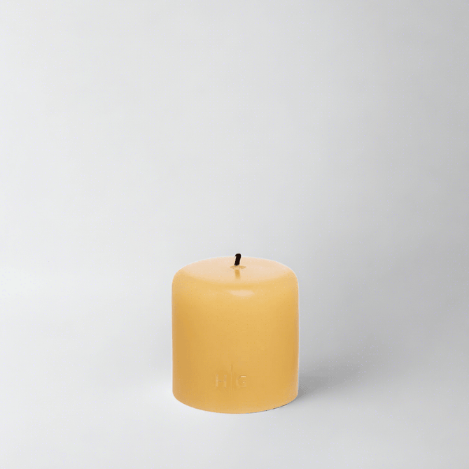 HG Amber Unscented Pillar Candle, 3"x3", with a gold embossed HG logo and black wick.