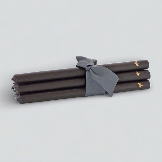 Set of 5 black 15" taper candles, hand-dipped paraffin, tied with a gray ribbon, gold HG logo.