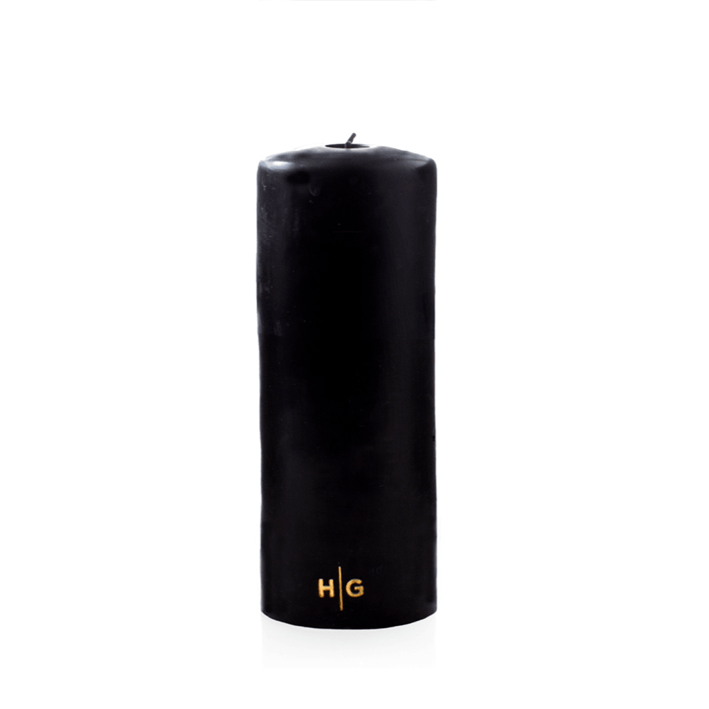 HG Black 3"x8" unscented pillar candle with gold HG logo.