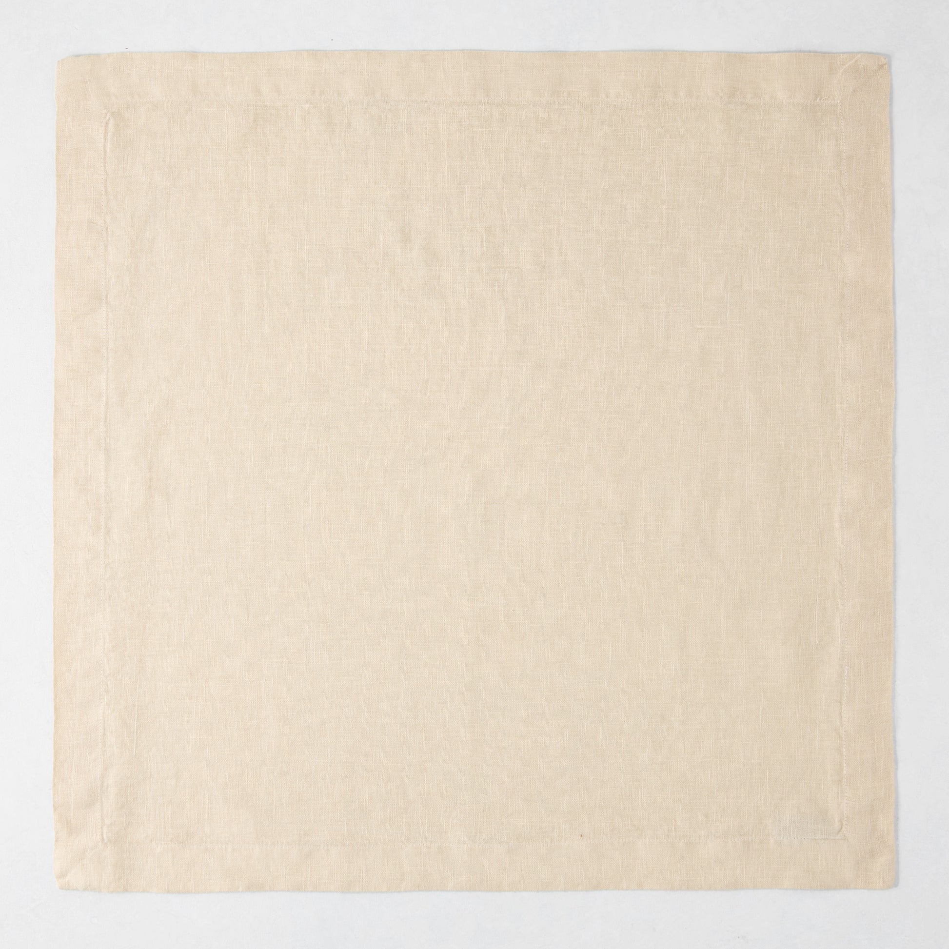 HG Buttermilk Hand-Dyed Linen Napkin, 22" square, light beige with mitered corners.