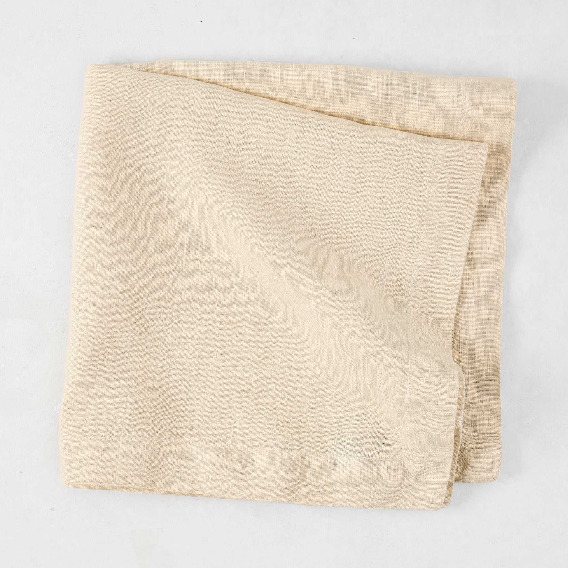 HG Buttermilk Hand-Dyed Linen Napkin, 22", folded, light beige with subtle texture.