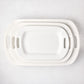 Set of 3 white ceramic serving platters with handles, nested from small to large.