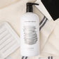 Hudson Grace Tart Kumquat dish soap, white ceramic soap dish, black and white sponges on a linen towel.