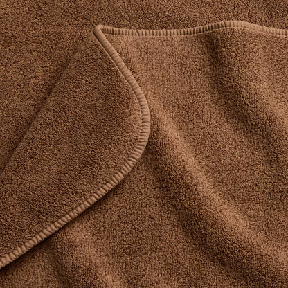 Coffee brown signature bath towel with a soft, plush cotton terry texture and a finished hemmed edge.